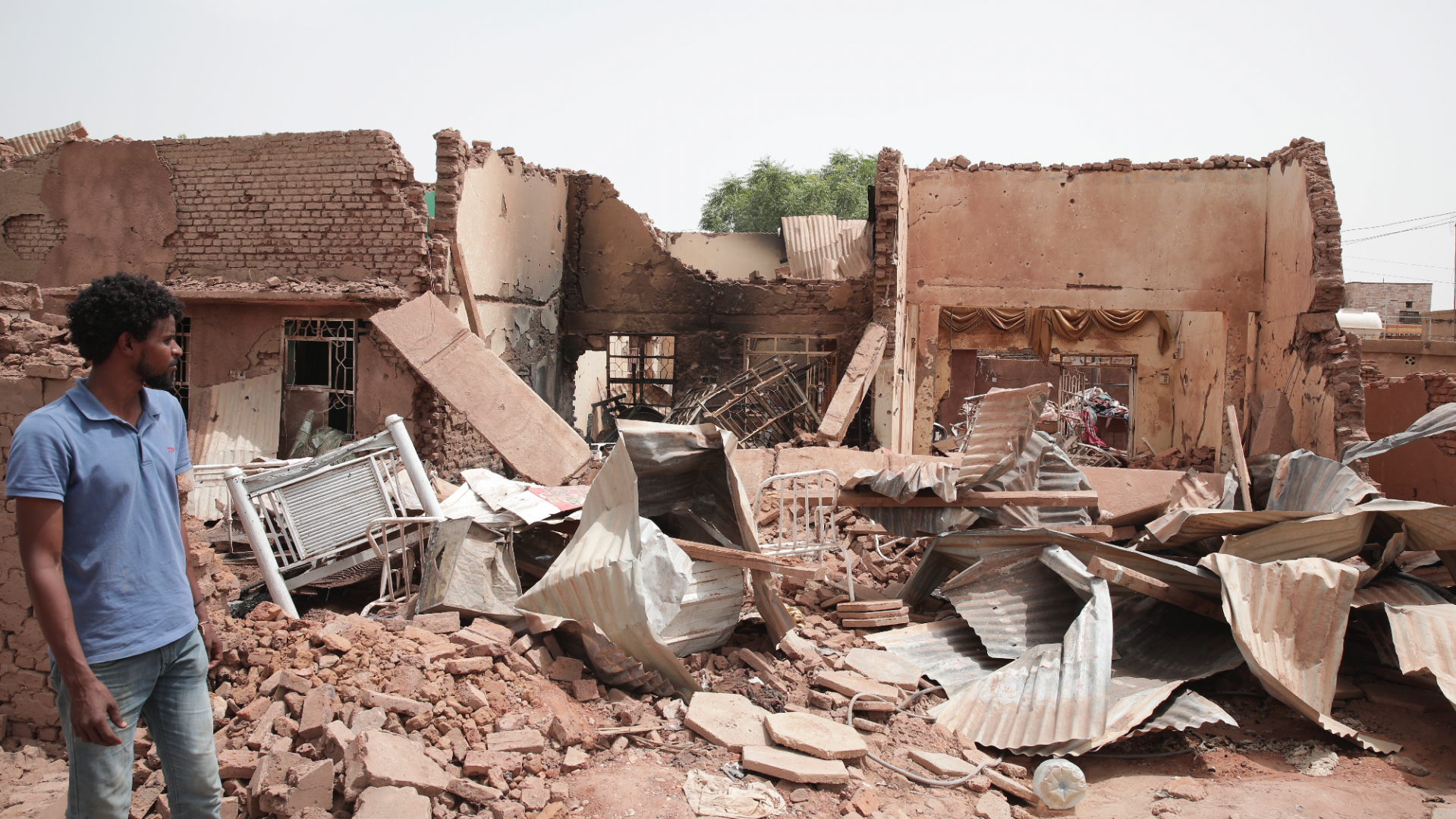 A man surveys the damage to a home in Khartoum as the fighting in Sudan continues.