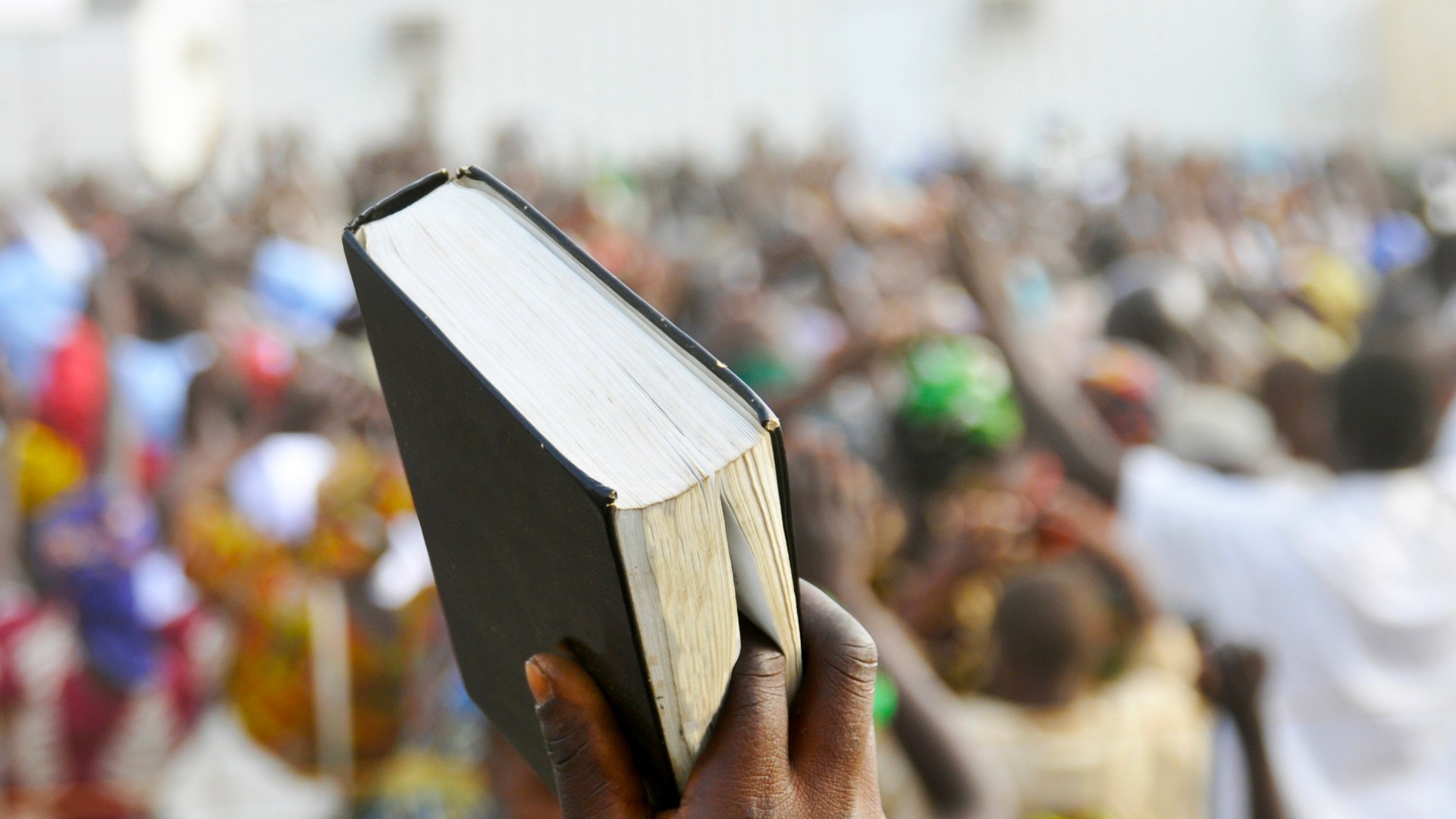 A Bible is raised during a worship service in Africa.