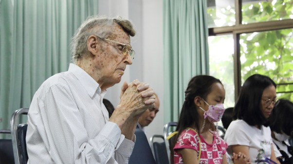 Retired missionary Henry Breidenthal praying at Grace New Life church in Chiang Mai, Thailand.