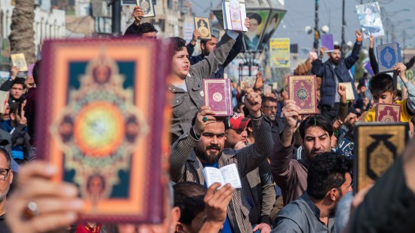 Protesters in Iraq hold up the Quran in response to the burning of a copy of the Quran in Sweden.