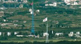 Flags of North Korea, rear, and South Korea, front, flutter in the wind as pictured from the border area between two Koreas.
