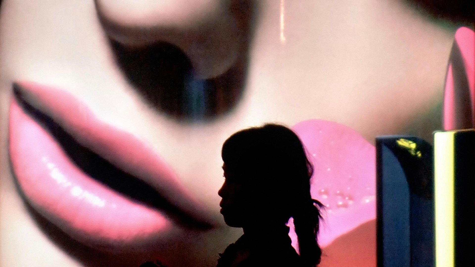 A woman walks past a promotional billboard at a shopping mall in Jakarta, Indonesia.