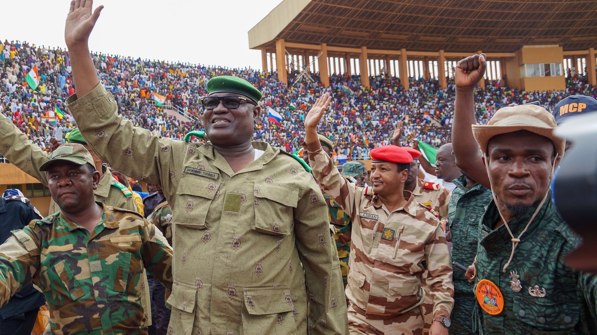 Mohamed Toumba (second to left), one of the leading figures of the National Council for the Protection of the Fatherland, greets coup supporters at a stadium in Niamey, the capital of Niger.