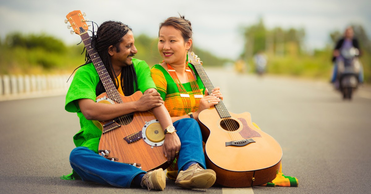 Benny Prasad, holding the bongo guitar that he designed, seated next to his wife, Zanbeni.