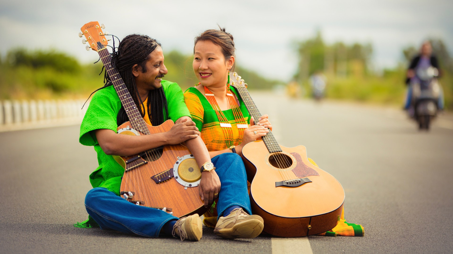 Benny Prasad, holding the bongo guitar that he designed, seated next to his wife, Zanbeni.