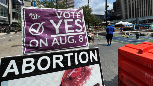 A sign asking Ohioans to vote in support of Issue 1 sits above another sign advocating against abortion rights at an event on July 20, 2023, in Cincinnati, Ohio.