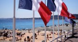 French flags fly over a beach in Nice, France.