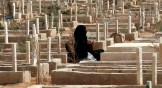 A Jordanian woman sitting beside the grave of a relative.