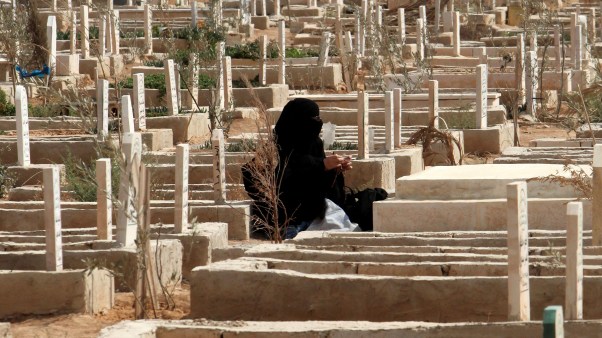 A Jordanian woman sitting beside the grave of a relative.