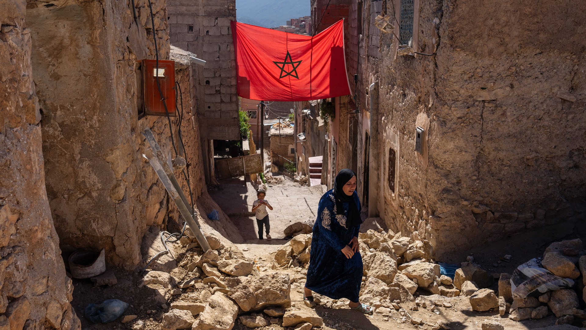 A woman walks past rubble from a building that was damaged during an earthquake in Morocco.