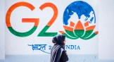 Bharat vs. India: A Kashmiri woman walks in front of a sign of this month's G20 summit.