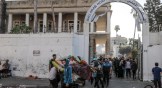 Palestinians carry usable items from the heavily damaged Al-Ahli Baptist Hospital building after bombing in Gaza City, Gaza, on October 18, 2023.