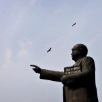 Birds fly over a statue of B.R. Ambedkar, who is regarded as the architect of India's constitution.