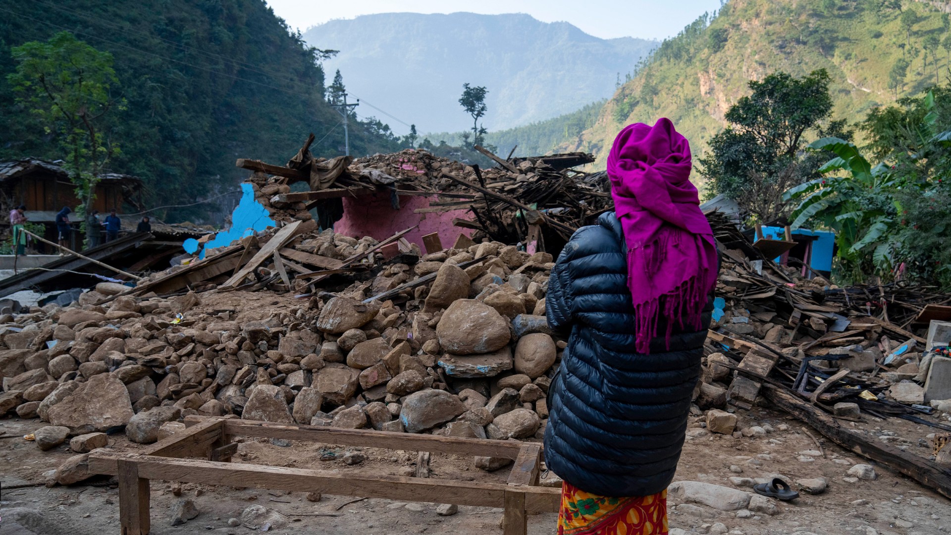A survivor looks at her earthquake damaged house in Rukum District, northwestern Nepal.