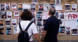 People look at a wall with photos of hostages kidnapped in the Hamas attack.
