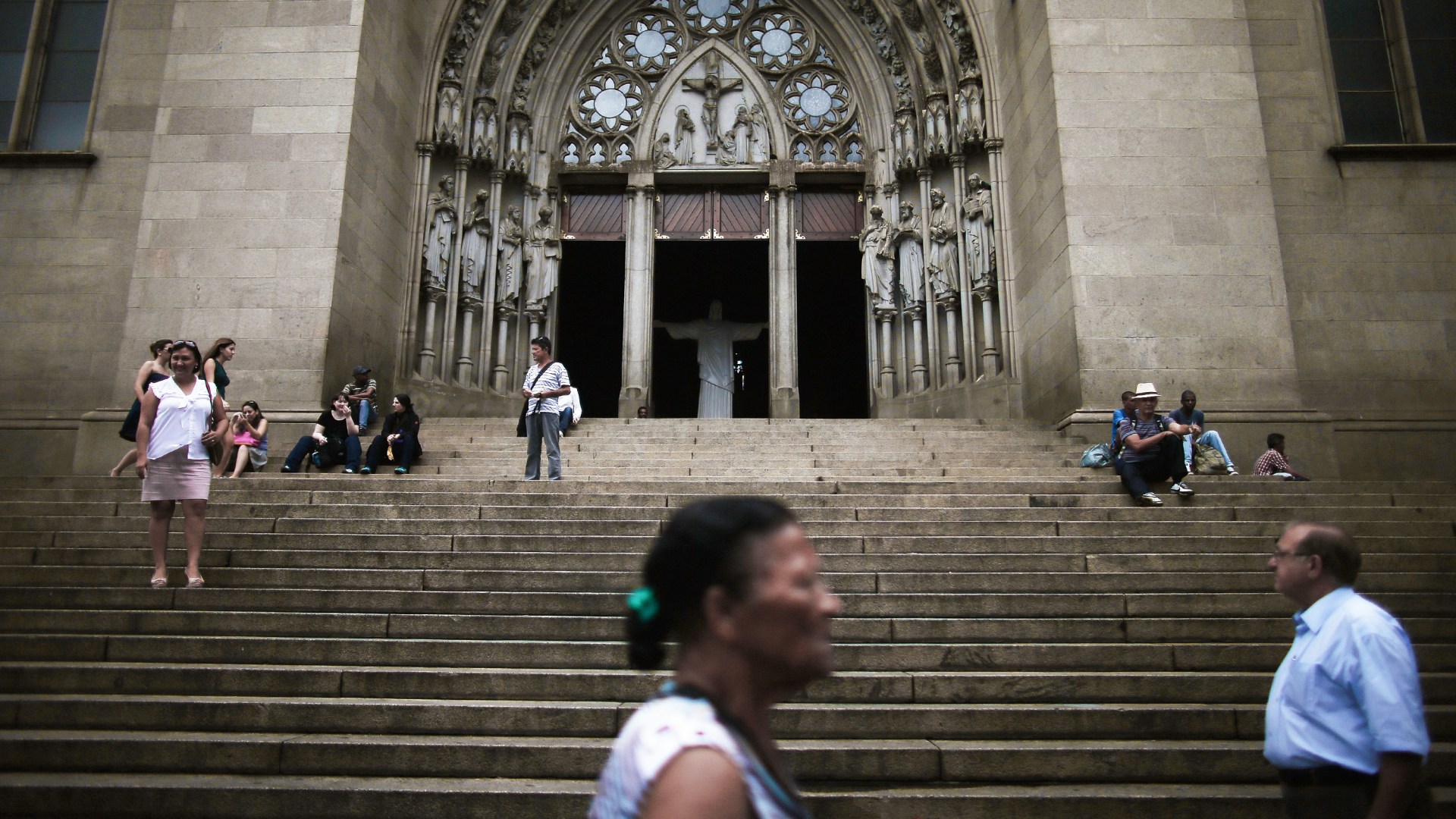 People walk past a Catholic church in Brazil.