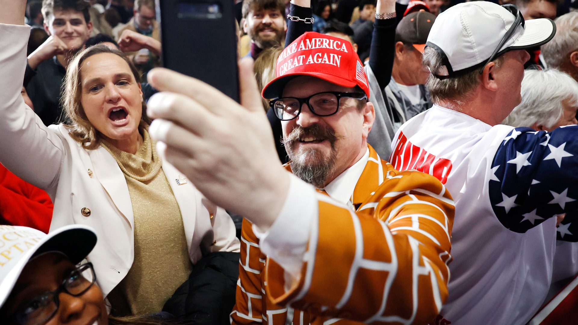 Supporters of former President Donald Trump celebrate at his caucus night event at the Iowa Events Center in Des Moines.
