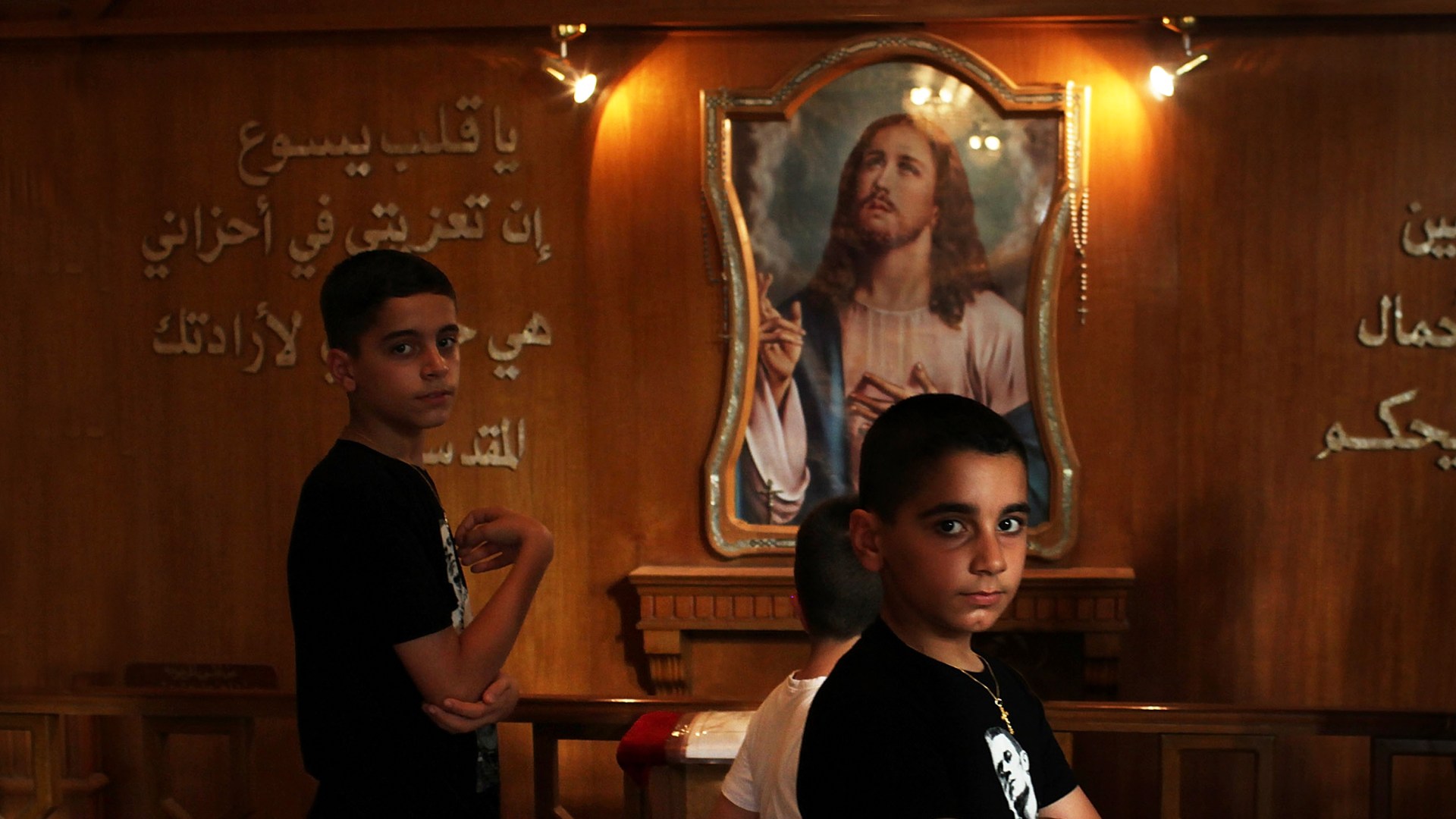 Iraqi Christian youths enter a Sunday service