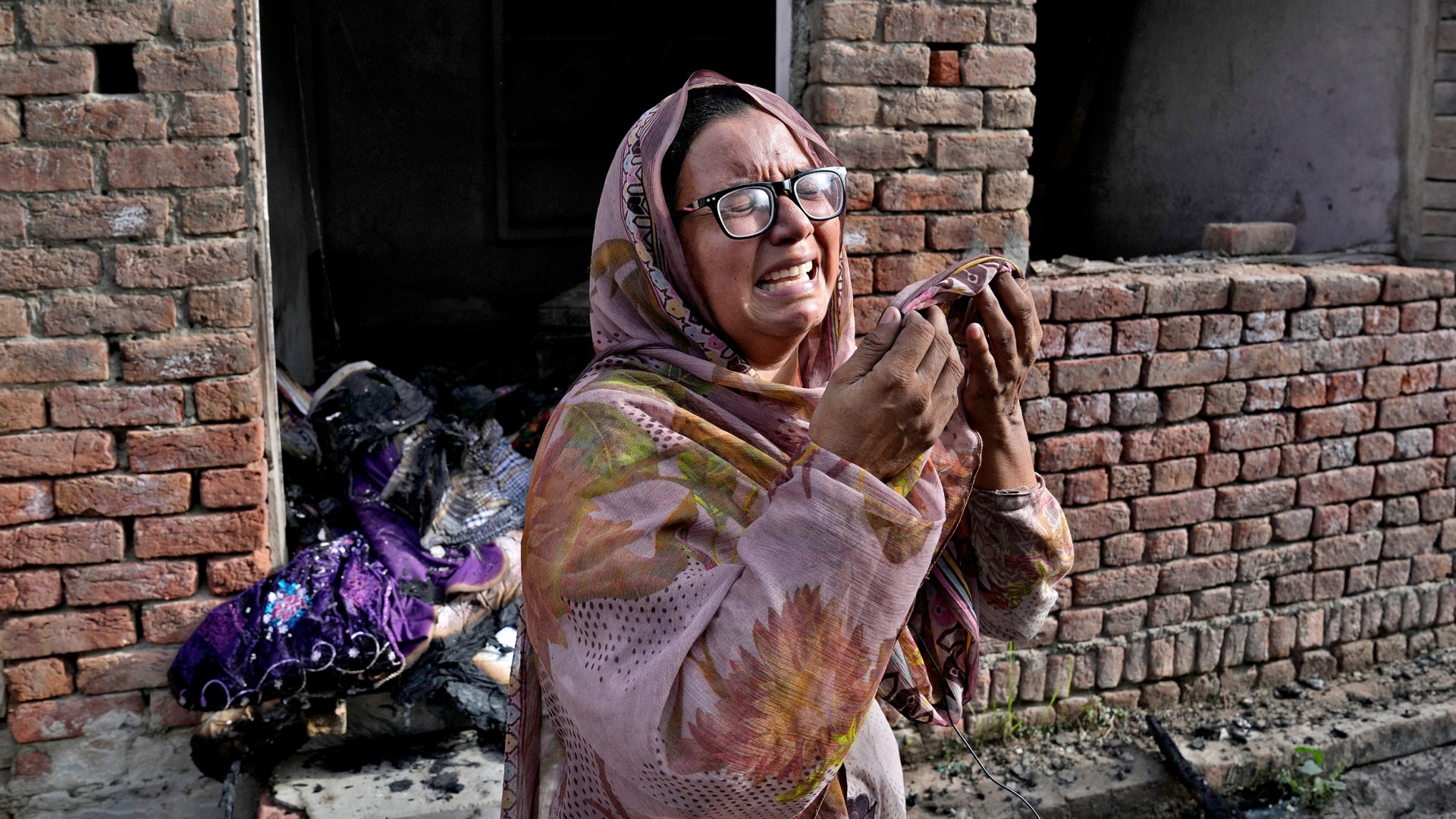 A Christian woman weeps after looking at her home vandalized by an angry Muslim mob in Pakistan.