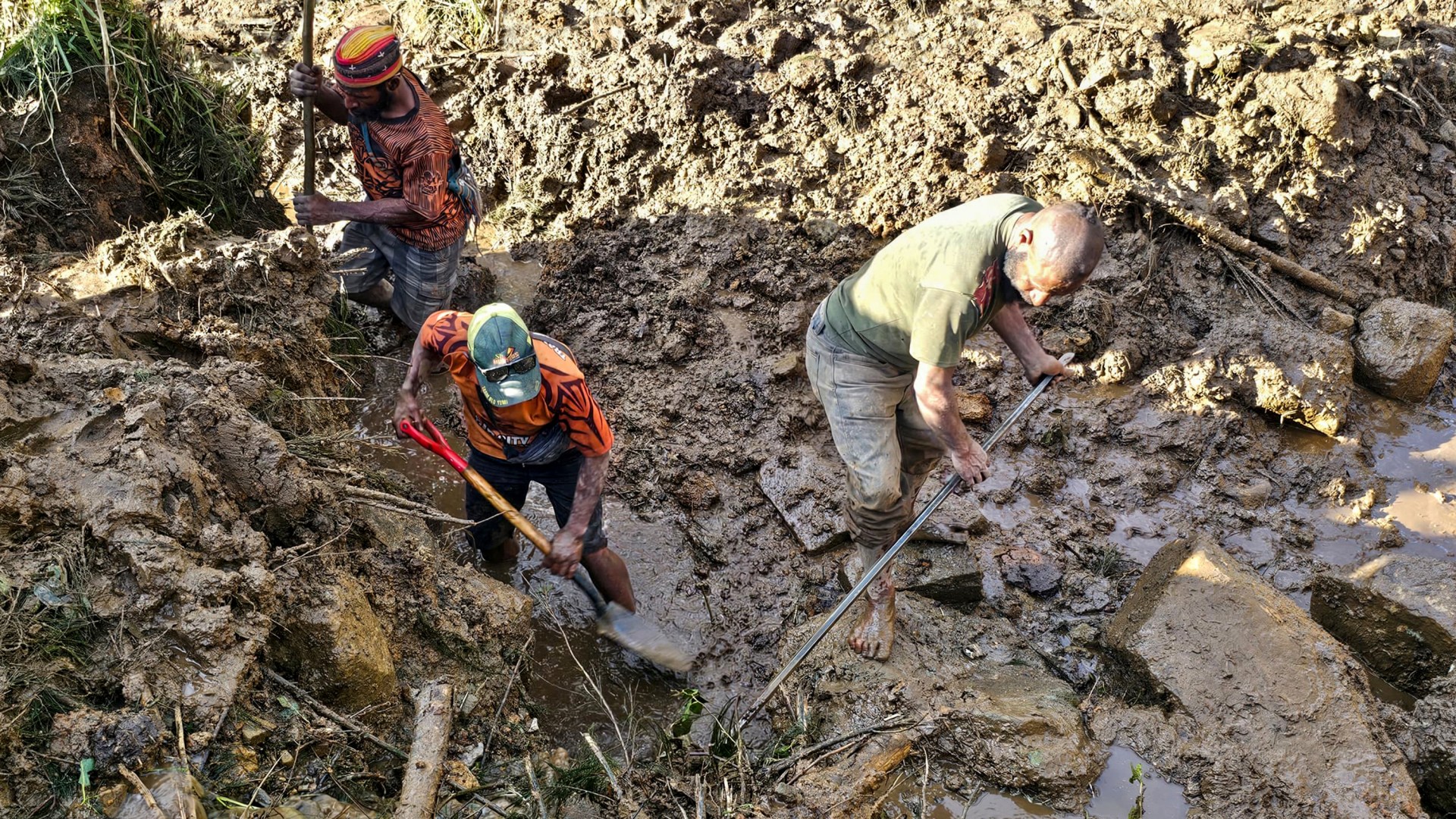 People dig through debris at the site of a landslide in Papua New Guinea.