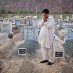 A father prays at the grave of his slain son who was murdered in an attack on an Ahmaddi mosque in Pakistan.