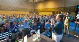 Worshipers in a conference meeting room sing and pray.