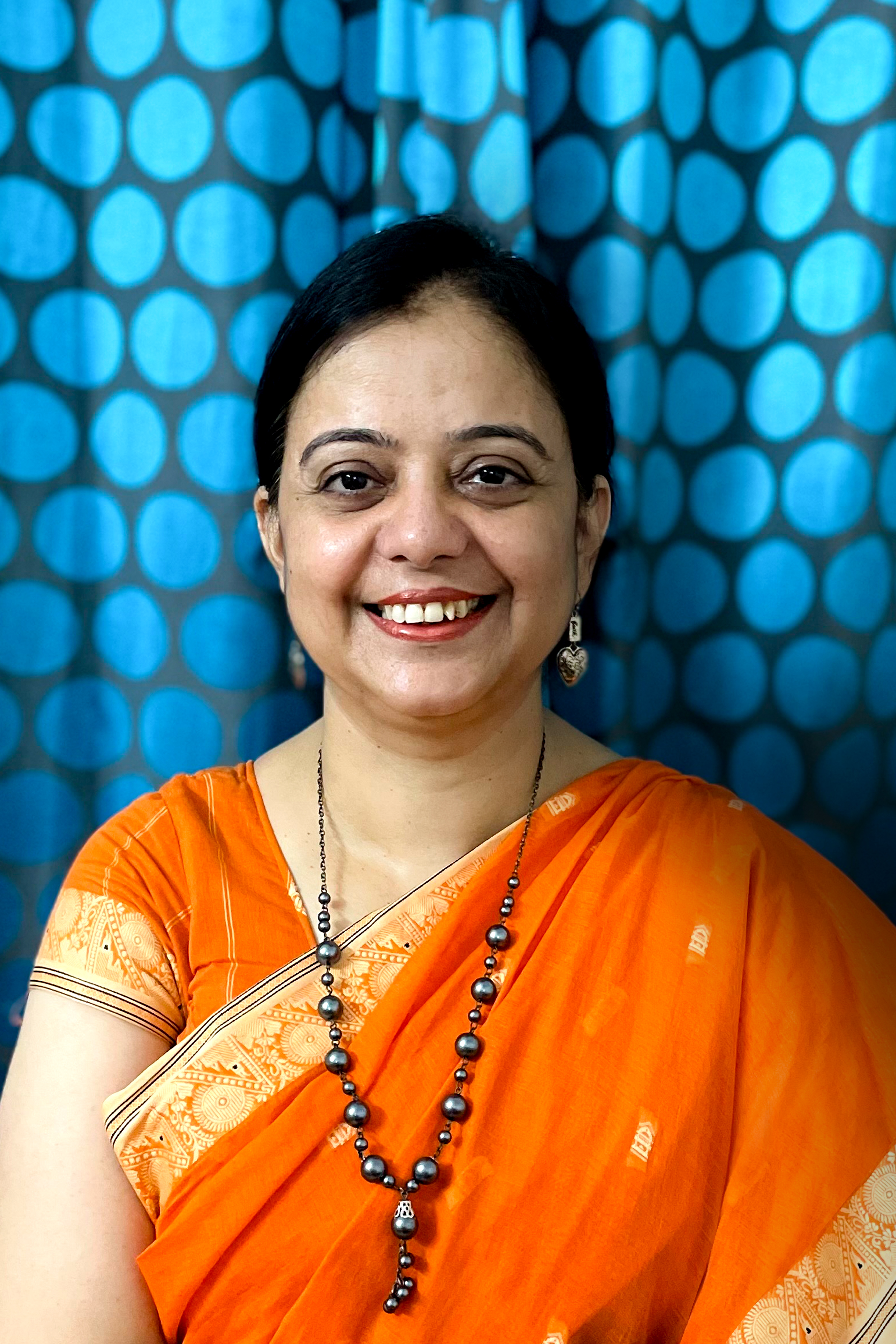 Surinder Kaur in front of a blue dotted cloth