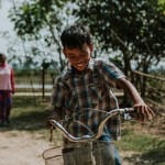 A foster child riding his bike in Cambodia