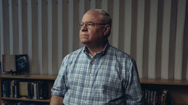 portrait of Keith Boyette standing behind a chair in a library