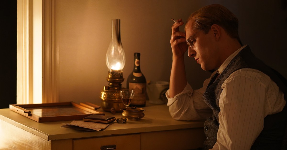 A still from the movie depicting Bonhoeffer sitting and thinking at his desk.