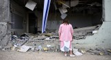 A woman standing in front of a ruined building in Israel.