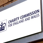 A sign of Charity Commission on a brick arch