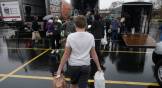 Boy carries plastic bags of food to a row of trucks at collection site.