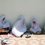 Philippine Muslim women wait for the start of their noon prayer outside a crowded Mosque.