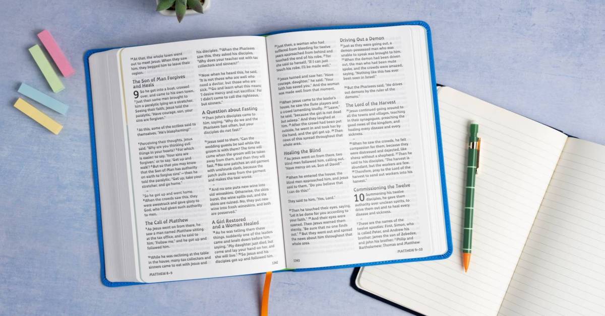 A Bible open to Matthew 9 and 10 in the new Grace Typeface, with a notebook beside it.