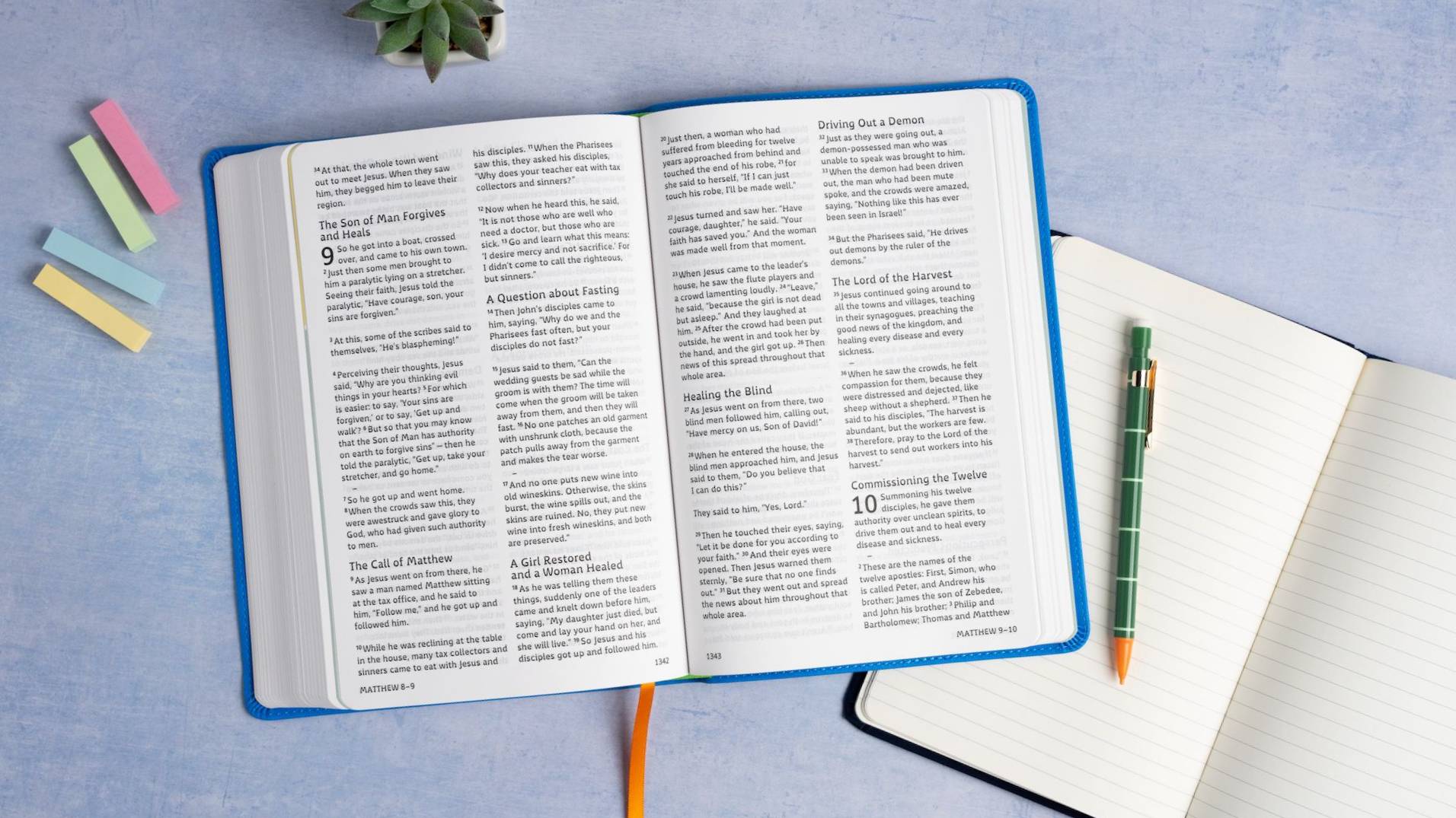 A Bible open to Matthew 9 and 10 in the new Grace Typeface, with a notebook beside it.