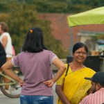 Indian family by a lemonade stand and bike riders