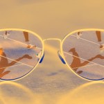 Glasses that have the reflection of athletes running in the lenses.