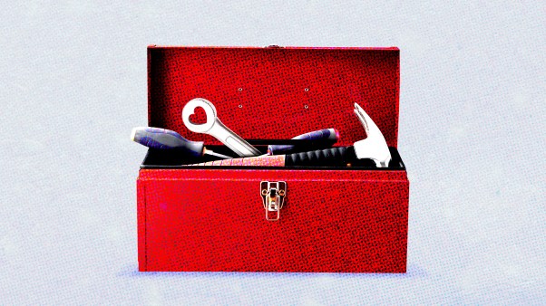 A wrench with a hole in the shape of a heart sticking out of a red toolbox.