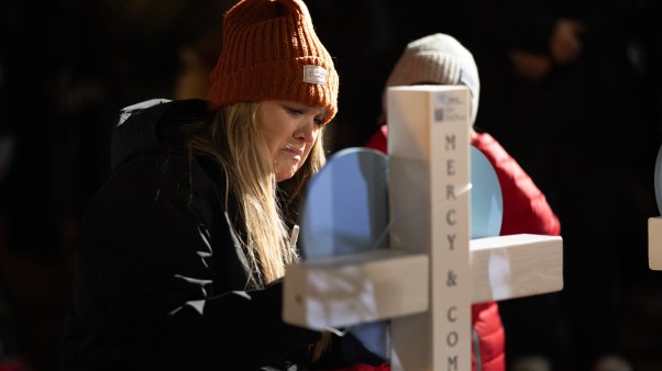 Locals gather to mourn at a vigil for victims of the Abundant Life Christian School shooting.