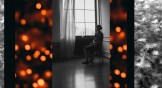 Woman sitting alone in a room with lights and snowflakes