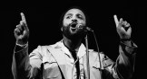 An image of Andraé Crouch performing.