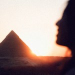 The shadow of a woman's face in front of an Egyptian pyramid