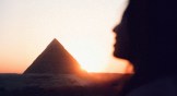 The shadow of a woman's face in front of an Egyptian pyramid
