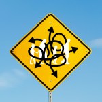 A street sign with arrows mixed up and an immigrant family walking through it