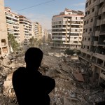 A man pauses as he looks at the rubble of destroyed buildings in Dahiyeh, Beirut, Lebanon