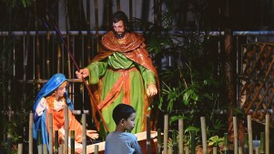 A Filipino boy in front of a nativity scene