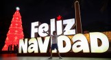 A child plays in front of a Merry Christmas sign as part of the Christmas celebrations in Venezuela