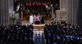 Cathedral with a flag-draped casket surrounded by clergy