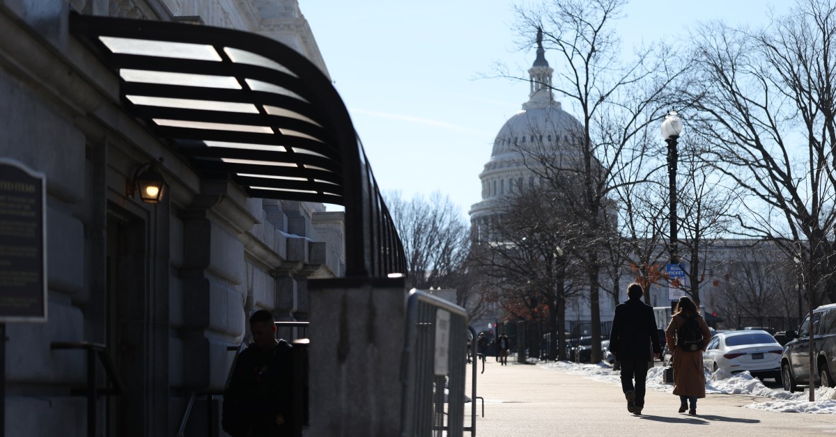 two people walking in DC in front of the Capitol building